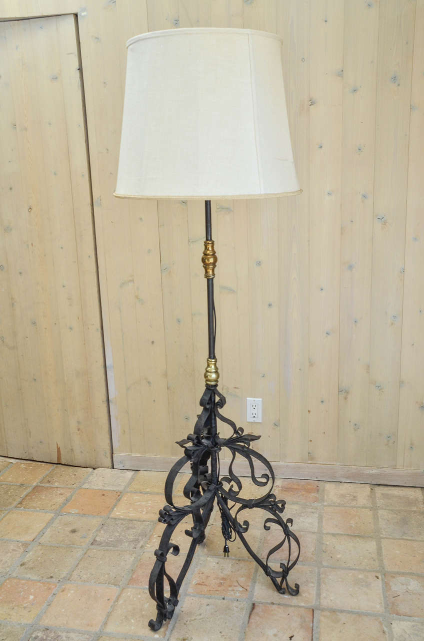The wrought iron shaft with gilt turned knobs on a scrolling tripod base.